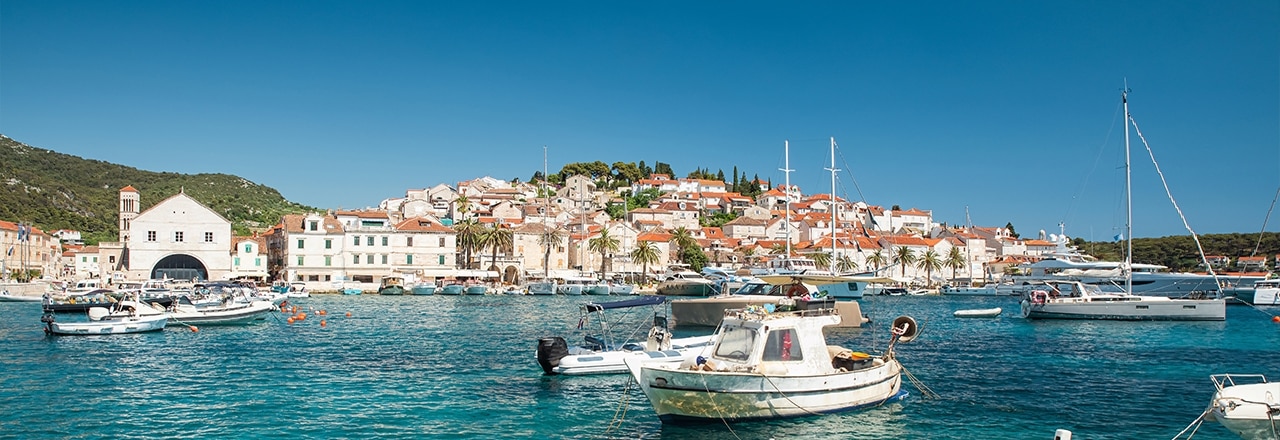 Hafen mit Booten in türkisfarbenem Wasser auf der Insel Hvar, Kroatien