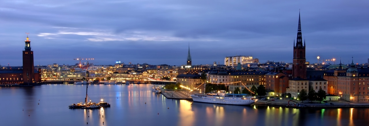 Blick auf Stockholm bei Nacht mit Spiegelungen im Wasser