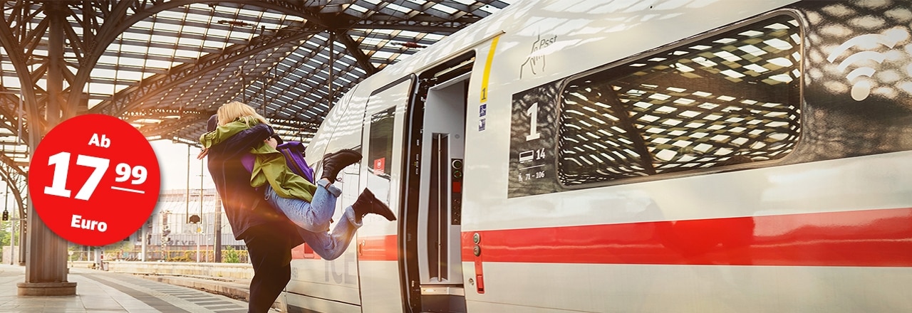 Junges Paar umarmt sich am Bahnhof