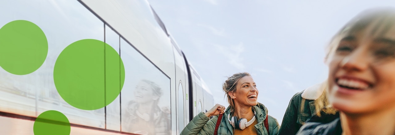 Lachende Frauen vor einem Zug