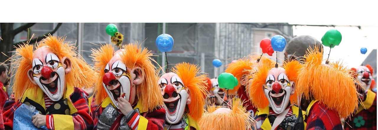 Als Clowns maskierte Menschen beim Fasnachts-Umzug