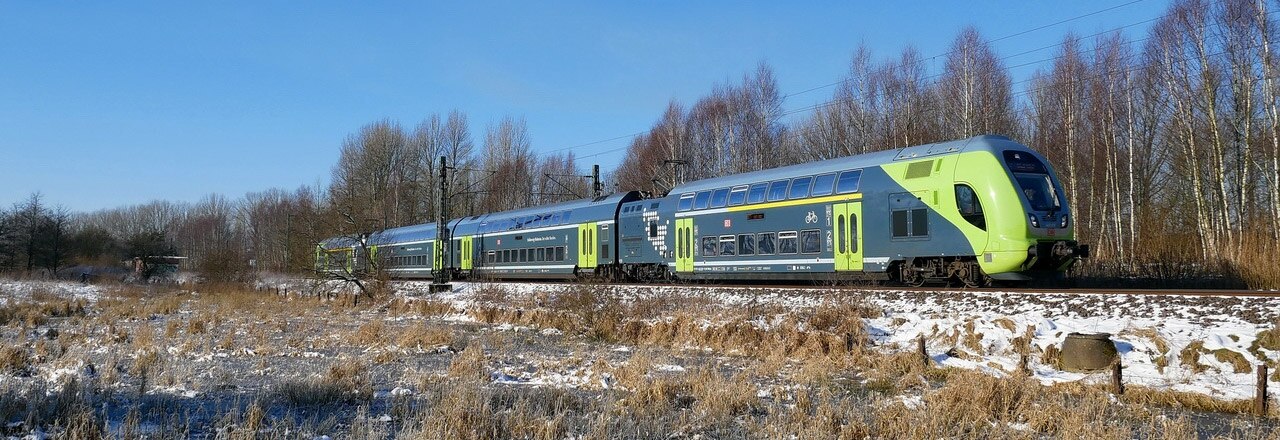 Doppelstock-Zug in verschneiter Landschaft