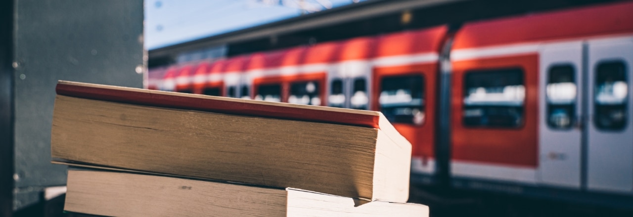 Bücher im Vordergrund und die S-Bahn München im Hintergrund