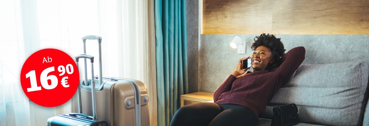Frau entspannt mit Gepäck im Hotelzimmer