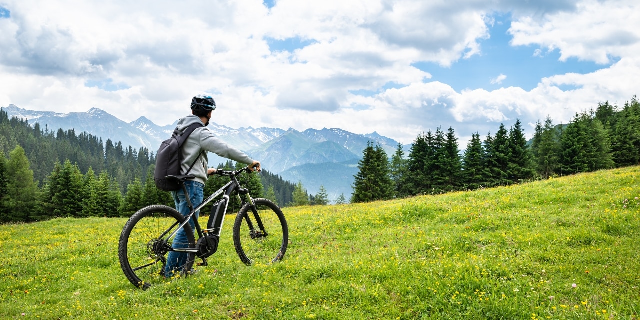 Mann mit Fahrrad in den Alpen