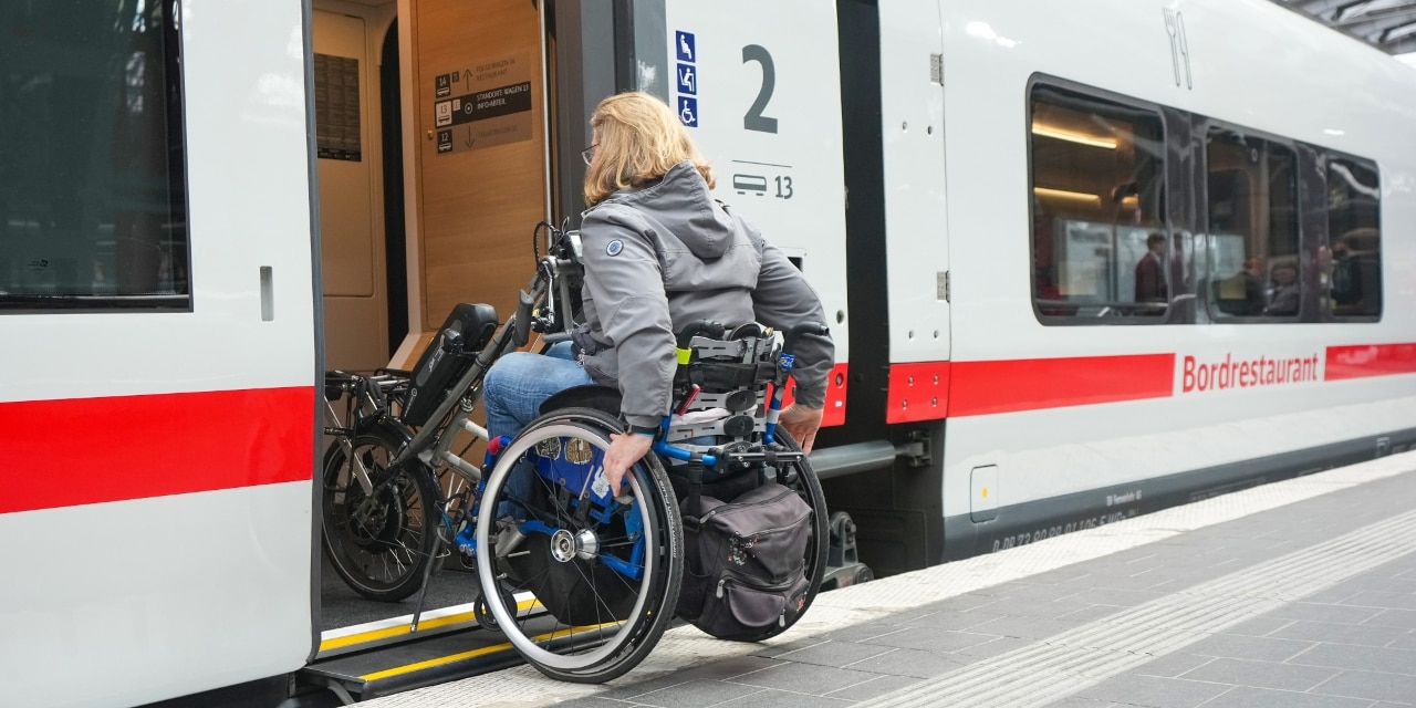 Person im Rollstuhl fährt in einen ICE L