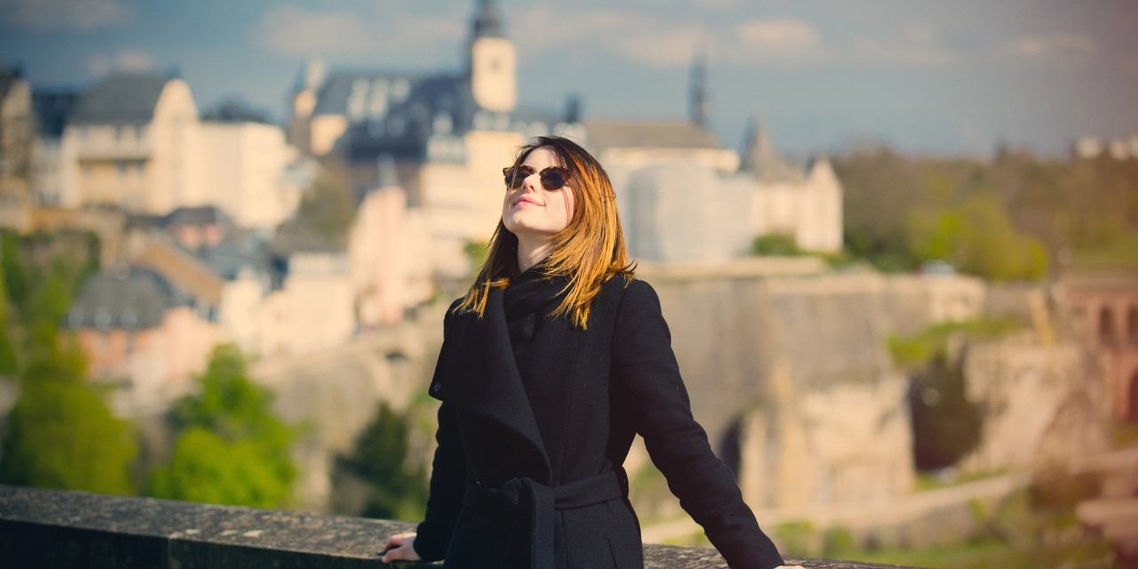 Junge Frau mit Sonnenbrille genießt die Sonne in Luxemburg