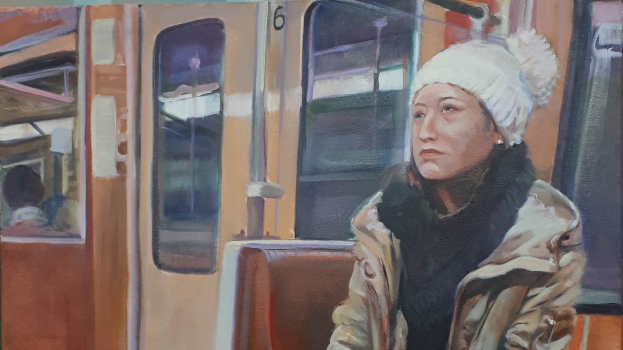 Kunstwerk von sitzender Frau in der Bahn