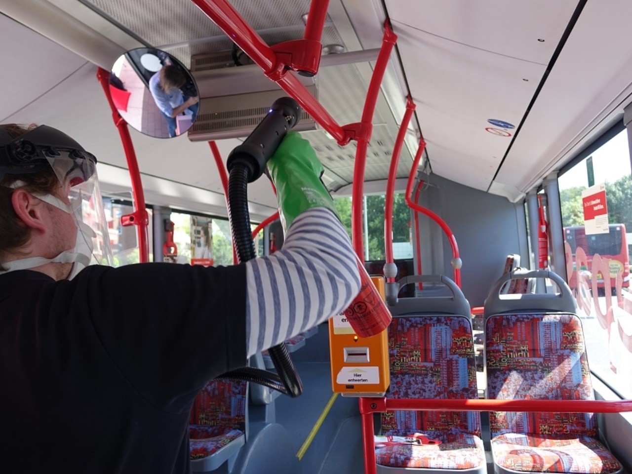 Mann mit Handschuhen beschichtet Handlauf im Bus