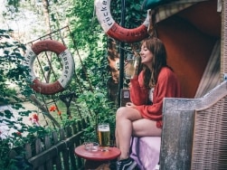 Frau sitzt in einem Lokal an einem Fluss