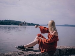 Frau sitzt am Ufer des Ammersees
