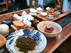 Asiatisches Porzellangeschirr auf Tisch mit Flüssigkeiten gefüllt