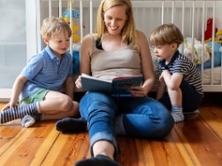 Mutter und zwei Kinder lesen ein Buch