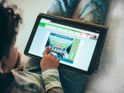 Kind spielt ein Bahn-Spiel am Tablet