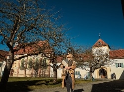 Frau mit Sonnenbrille steht vor Schloss Blutenburg