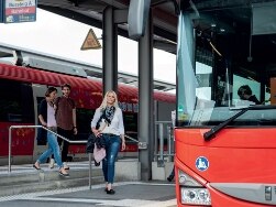 Frau steigt von Regio Zug in DB Regio Bus um