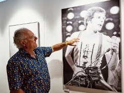 Mann zeigt auf Poster von Freddie Mercury