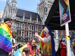 Mehrere Personen mit Regenbogenflaggen und Verkleidung am Marienplatz