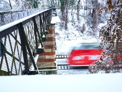 Blick von Brücke auf vorbeifahrenden Zug