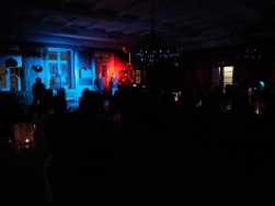 Mensch im Dunkeln auf Bühne mit rotem und blauem Licht