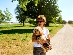Eine Frau mit Hund auf dem Arm im Park