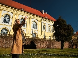 Frau macht ein Selfie vor dem Schloss Dachau