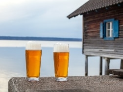Zwei Gläser Bier vor einem See
