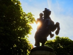 Statue von Reiter auf Pferd vor der Sonne