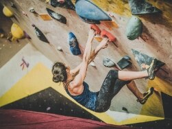 Frau klettert in der Boulderwelt München Ost