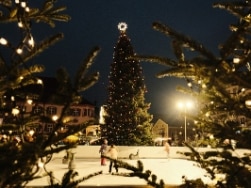 leuchtender Weihnachtsbaum auf schneebedecktem Platz