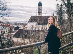 Eine Frau steht an einem Aussichtspunkt mit Blick über Wolfratshausen