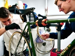 Zwei junge Männer reparieren ein Fahrrad
