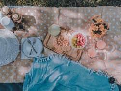 Picknickdecke mit Picknickutensilien auf einer Wiese