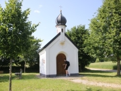 Ein Wanderer an der Tür einer Kapelle