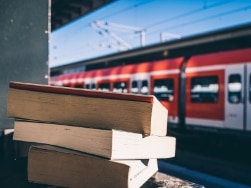 Bücherstapel auf einem Geländer am Bahnsteig