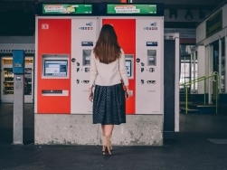 Frau im Dirndl steht an einem Ticketautomaten