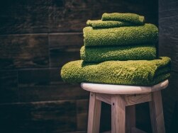 Grüne Handtücher auf einem Hocker