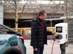 Mann lädt E-Auto an Ladestation auf