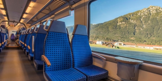 Sitzplätze im Regionalzug mit Panorama-Blick auf Landschaft