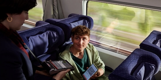Die Zugbegleiterin kontrolliert das Handy-Ticket eines jungen Mannes