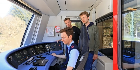 Drei junge Männer in Führerkabine einer S-Bahn