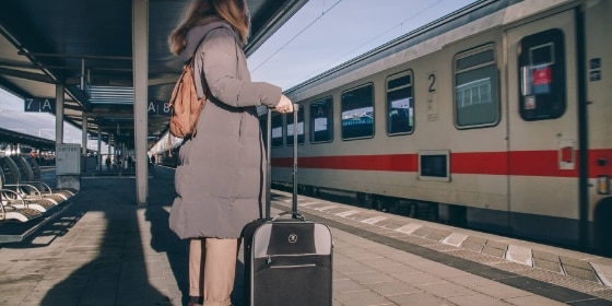 Person mit Koffer am Bahnsteig