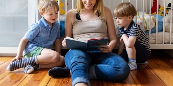 Mutter und zwei Kinder lesen ein Buch