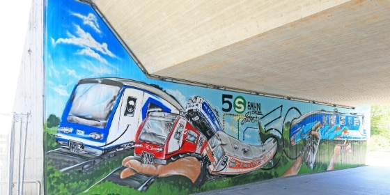 Graffiti mit mehreren S-Bahnen an der Wand einer S-Bahnstation