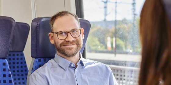 Mann mit Brille im Regionalzug
