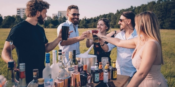 Fünf Personen bei einem Cocktailtasting im Park