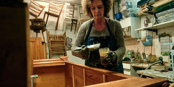 Eine Frau restauriert ein Möbelstück