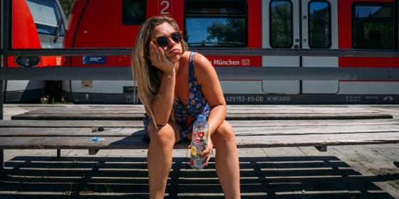 Person sitzt auf einer Bank am Bahnsteig