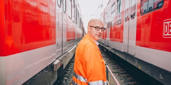 Lokrangierführer läuft zwischen S-Bahnen im Werk Steinhausen entlang