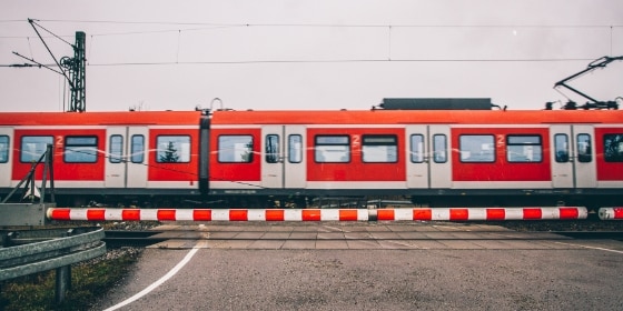 S-Bahn passiert hinter einer geschlossenen Schranke